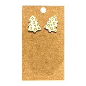 Détail de boucles d'oreilles sapin de Noël avec imprimé léopard doré sur fond blanc.