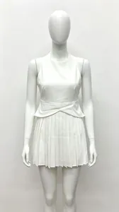 Détail d'une élégante robe blanche sans manches avec jupe plissée et taille cintrée.