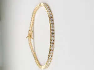 Vista dettagliata di un bracciale tennis dorato con una fila di zirconi trasparenti