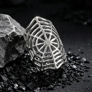 Close-up detail of silver spider web gothic ring on dark textured stone background