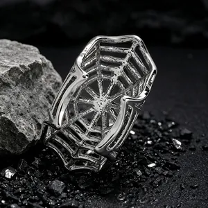 Detailed close-up of a silver gothic spider web ear cuff on dark stones