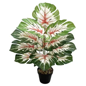 Realistische künstliche Monstera-Pflanze im schwarzen Topf für nordische Wohndekoration.