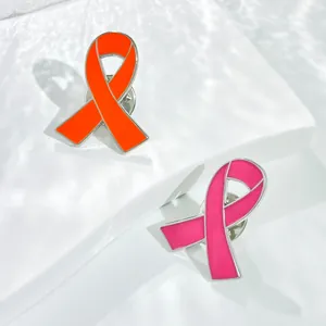 Detailweergave van oranje en roze emaille lintspelden gepresenteerd op een witte ondergrond.
