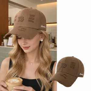Detailed view of a brown distressed cotton baseball cap with DG embroidery on a model