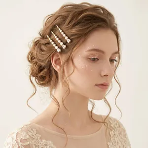 Elegante goudkleurige haarpelden met zirkoon gedragen door een model in een bruidskapsel.