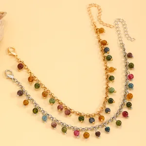 Detail view of gold and silver chain bracelets with vibrant multi-colored hanging beads.