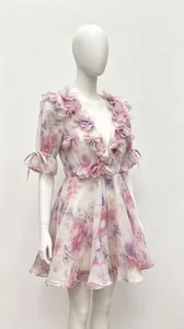 Detail of French floral dress with 3D chiffon flowers and puff sleeves on mannequin