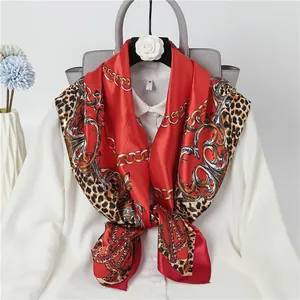Elegant red satin square scarf featuring leopard and gold chain prints on white shirt