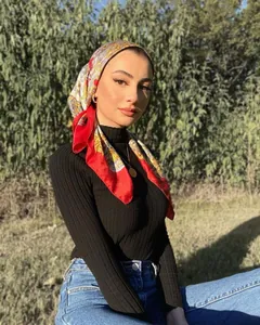 Close-up of a model wearing a retro paisley printed red silk scarf as a stylish headscarf