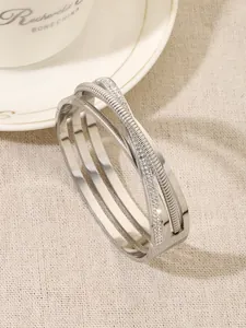 Detail view of multi-layer intertwined silver bangle with sparkling rhinestones