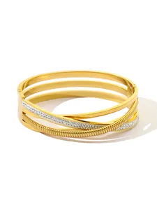 Detail view of a hollow multi-layer gold-plated bangle with sparkling crystal inlay.