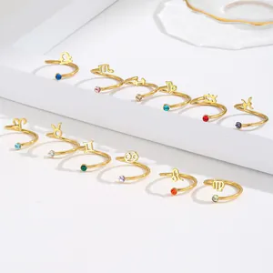Detailed view of twelve gold-plated zodiac rings with sparkling colored crystals