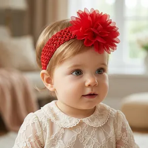 Detailed view of baby girl wearing a large red chiffon flower elastic headband