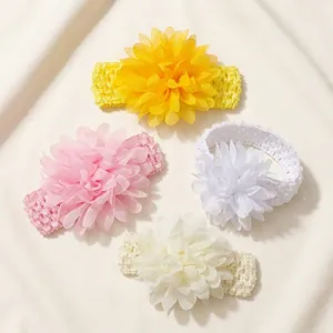 Close-up of four soft chiffon flower headbands in yellow, pink, white, and cream shades.