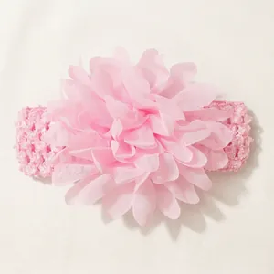 Detailed view of large pink chiffon flower on soft elastic hairband for infants