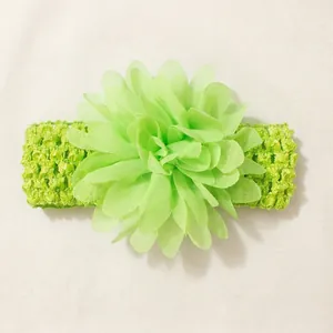 Close-up of a light green chiffon flower on an elastic crochet baby headband.