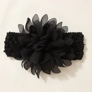 Detail view of baby elastic headband with a large multi-layered black chiffon flower ornament