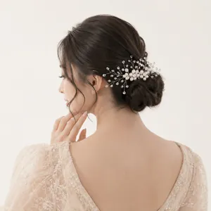 Elegant bridal hair comb with pearls and crystals on a model's updo hairstyle