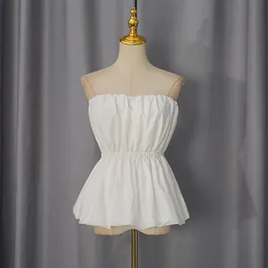 Detail view of a white strapless tube top with ruffled hem and elastic waist on mannequin.