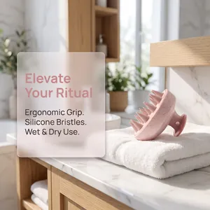 Pink silicone scalp massager brush detail shown on a soft white towel in a bathroom