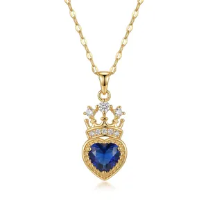 Primer plano detallado de collar con colgante de corazón y corona con gema azul zafiro
