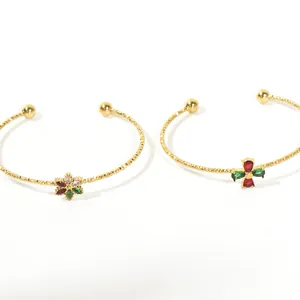 Detailed view of two gold titanium steel bracelets with colorful marquise-cut zircon flowers