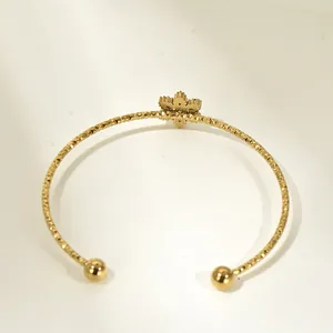 Gold cuff bracelet featuring colorful zircon geometric floral design and textured band