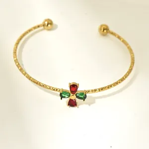 Elegant gold open cuff bracelet featuring vibrant red and green pear-cut zircon stones