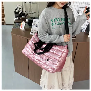 Nahaufnahme eines Models mit einer großen, rosa metallischen Stepp-Puffertasche