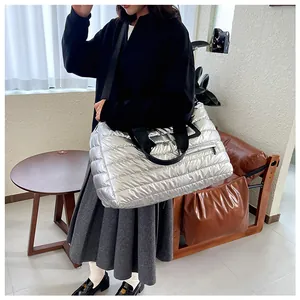 Silberne gesteppte Puffer-Tasche getragen von einem asiatischen Model innen