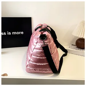 Seitenansicht der glänzenden Textur und des schwarzen Riemens der pinken Stepptasche