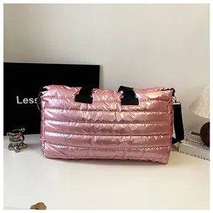 Detailansicht der großen pinkfarbenen gesteppten Reisetasche mit schwarzen Riemen