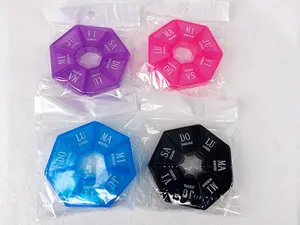 Détail de quatre piluliers octogonaux colorés de 7 jours dans leur emballage