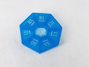 Gros plan d'un pilulier bleu de 7 jours avec les étiquettes de la semaine en espagnol