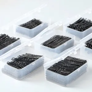 Close-up detail of black Bobby pins organized in mini transparent plastic storage boxes