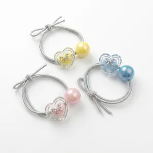 Set of three colorful heart and bow hair ties with iridescent beads for girl's hairstyles