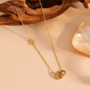 Detalle de collar de acero de titanio chapado en oro de 18k con anillos de trébol