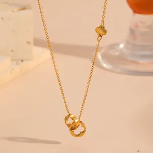 Detalle del colgante de anillos entrelazados con trébol calado en acabado oro 18k