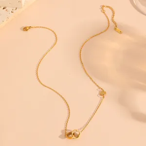 Detalle de collar de acero de titanio chapado en oro de 18K con colgantes de trébol.