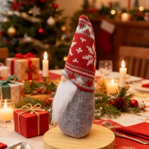 Festive Christmas gnome doll with red knitted snowflake hat on a decorated dinner table
