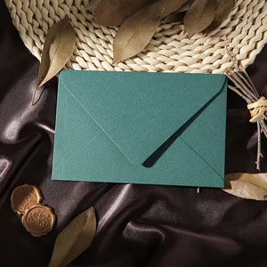 Detailed view of a premium teal linen-textured vintage envelope placed on brown satin