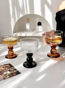 Close-up of vintage ribbed glass goblets with colorful ball stems in a bright interior setting