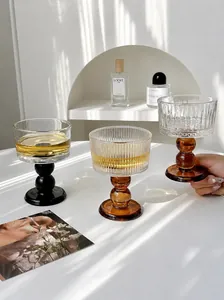 Detail of three vintage ribbed glass wine goblets on a white table with elegant props.