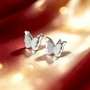 Nahaufnahme eleganter zweilagiger Schmetterling-Ohrstecker in mattiertem Silber-Finish