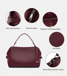 Detail view of burgundy handbag showing zipper, magnetic snap and soft fabric texture