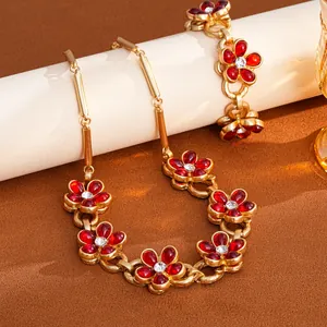 Detailed view of luxury vintage floral chain necklace set with red crystals and gold finish