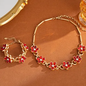 Macro detail of vintage red flower jewelry set with gold-tone necklace and bracelet