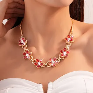 Detail view of a retro floral necklace featuring red crystals and sparkling rhinestones.