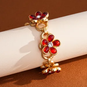 Close-up detail of the vintage red floral chain bracelet with rhinestone center.