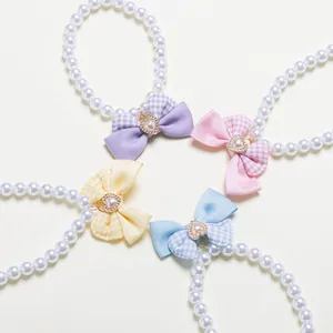 Detailed view of pet pearl collars with bows in four colors and heart charm accents